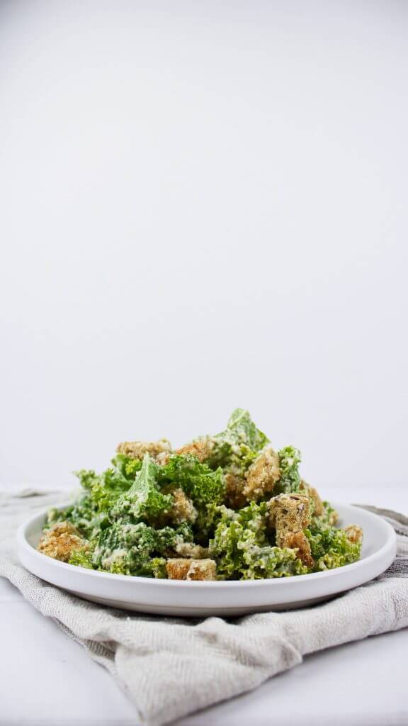Easy kale vegan Caesar salad with roasted garlic which will keep your family full and happy in summer time
